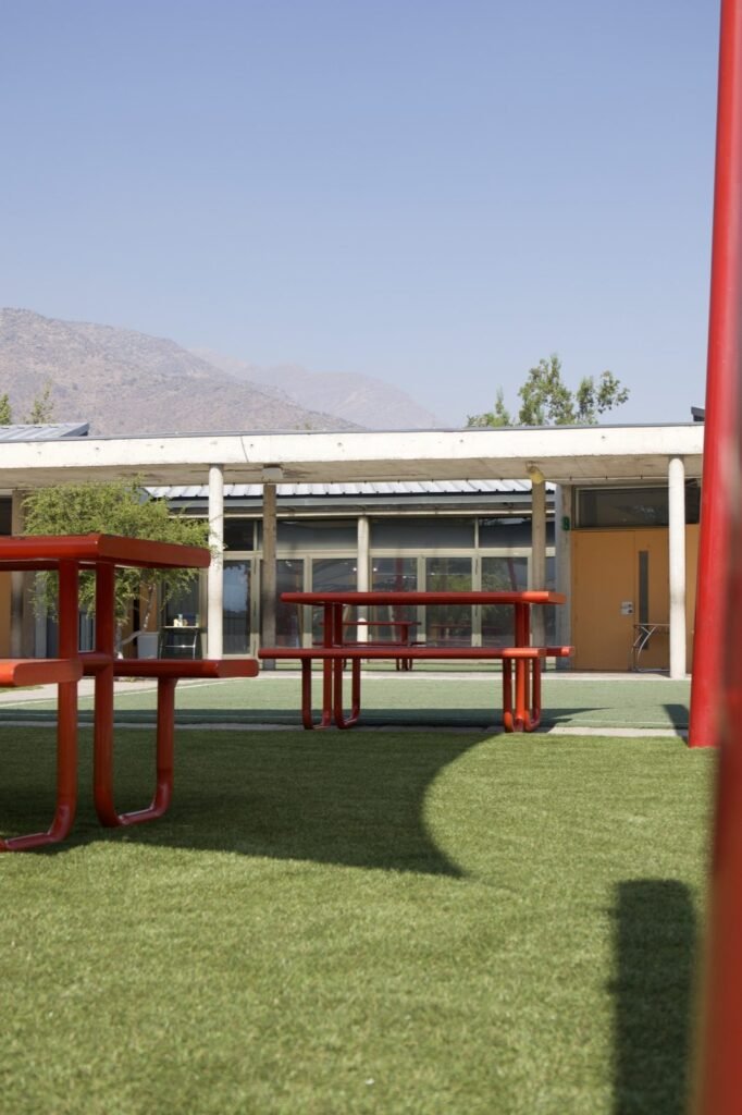 Pasto sintético instalado junto a juegos infantiles de un colegio