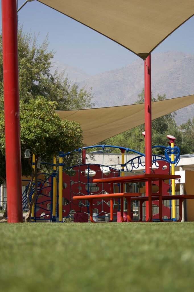 Pasto sintético bajo malla de sombra en un colegio