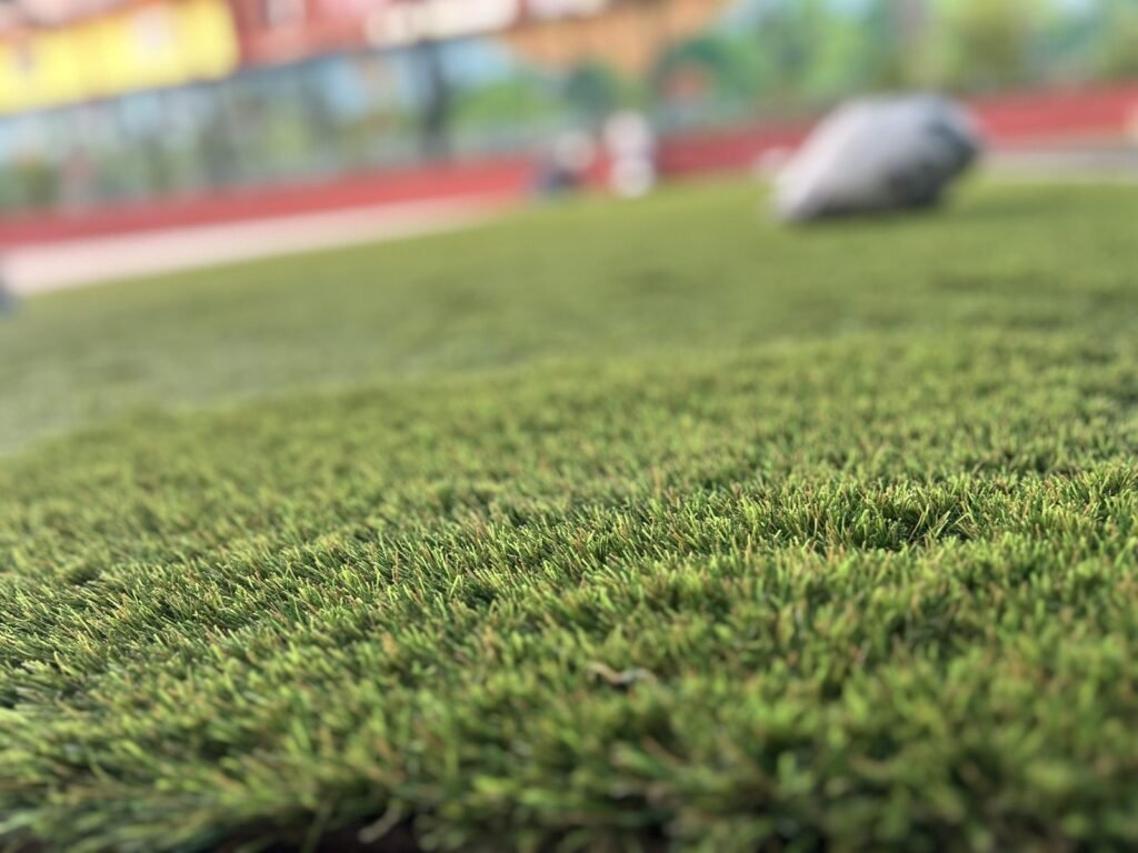 Primer plano de las fibras del pasto sintético instalado en un patio de colegio