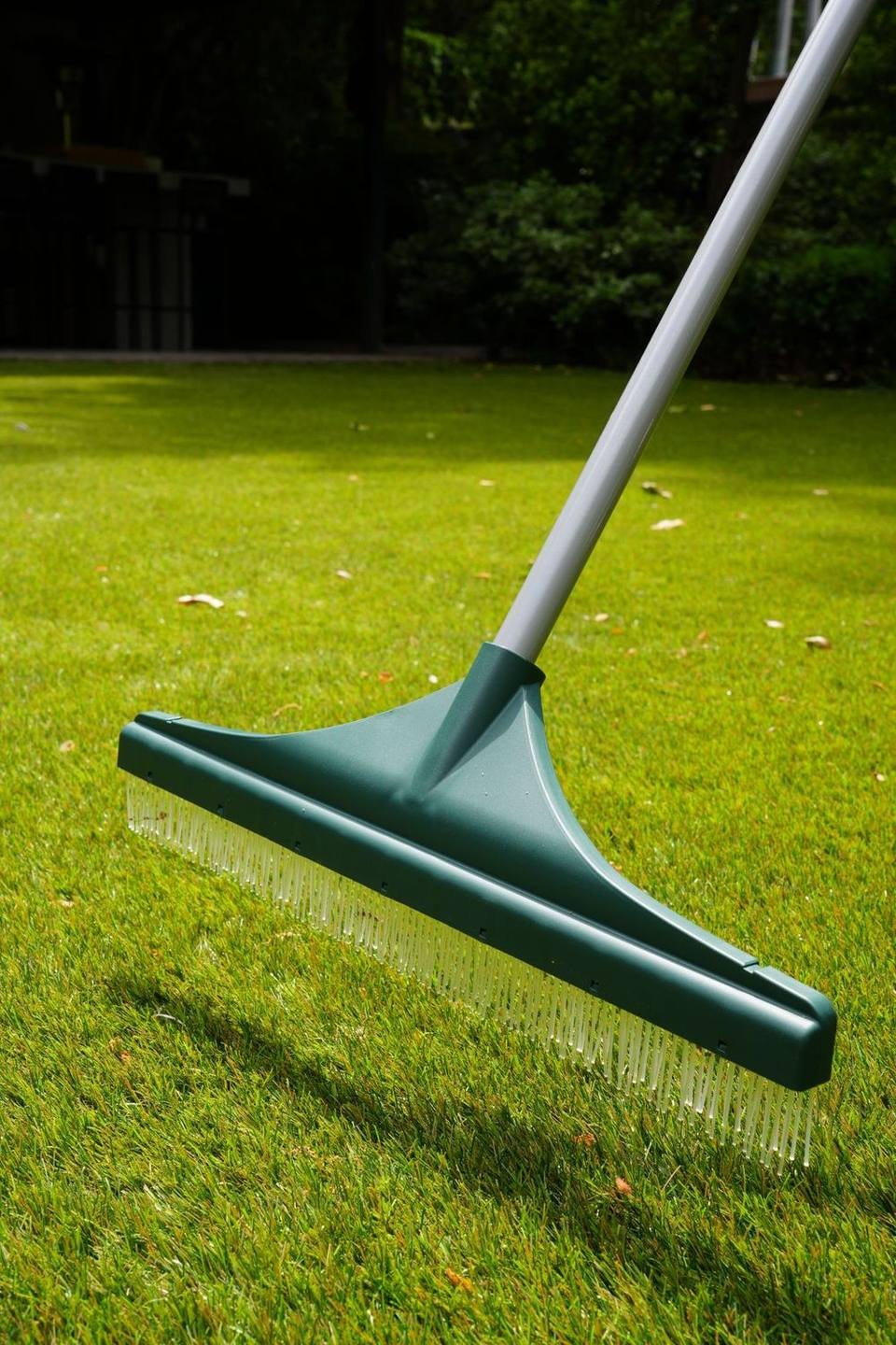 Rastrillo para pasto sintético apoyado sobre el césped artificial